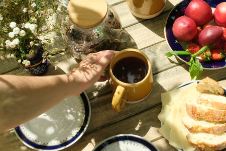 Person set table for outdoor tea party.