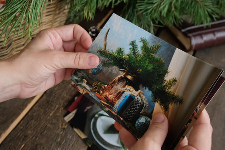 Person looking at printed winter and Christmas photosの写真素材
