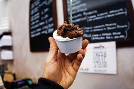 man holding chocolate ice cream. ice cream on the cup. ice cream shop.の写真素材