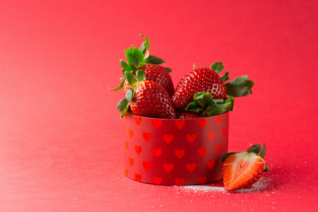 Juicy fresh strawberries and powdered sugar on red background, selective focusの写真素材