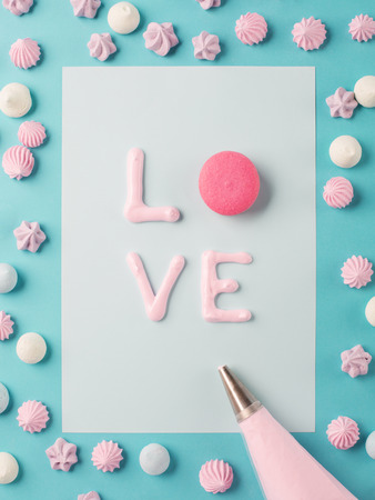 Whipped egg whites, macaroon and colorful meringue cookies, retro blue background. Baking dessert  love concept. Top viewの写真素材