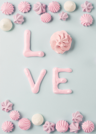 Whipped egg whites and colorful meringue cookies, retro blue background. Baking dessert love concept. Top viewの写真素材