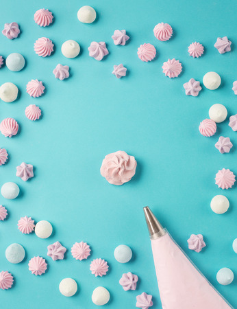 Whipped egg whites and colorful meringue cookies, retro blue background. Baking dessert concept. Top viewの写真素材