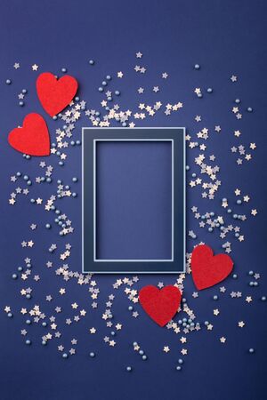 Happy Valentine's Day card with small stars and red hearts on classic blue background. Holiday time concept. Mockup template. Top viewの写真素材