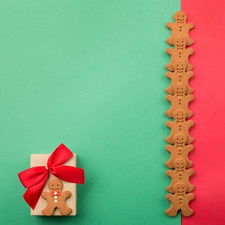 Christmas or new year composition. Gift and winter gingerbread cookies on green background. Holiday...