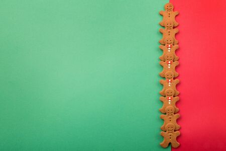 Traditional christmas homemade gingerbread men cookies on red green background. Holiday, celebration...