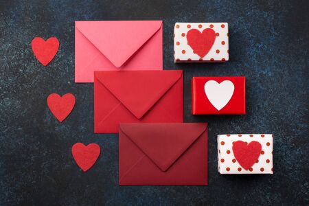 Red envelopes, gifts and red hearts on classic blue background. Love letter, Valentines card,...