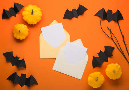 Halloween party greeting card mockup with copy space on orange background. Black bats, pumpkins and...