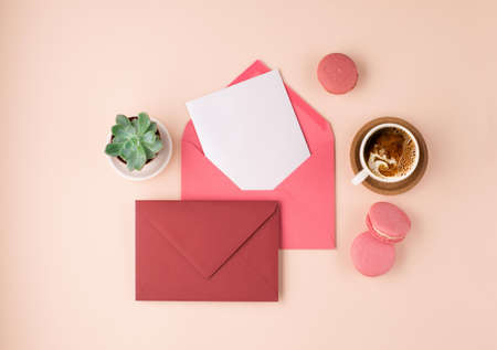 Mockup with postcards, sweets and cup of coffee on beige background. Pink envelopes with empty card...