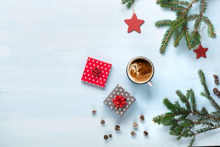 Rustic blue wooden background with cup of hot coffee, Christmas gifts and fir branches. Seasonal background shot from above. Flat lay, top view, copy space.の写真素材