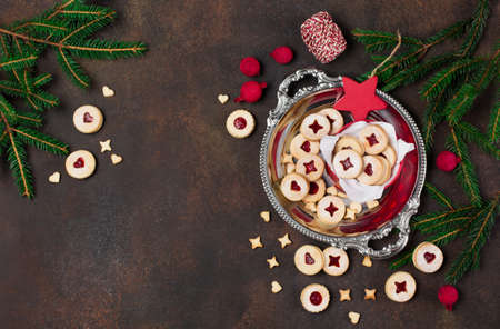Linzer Christmas or New Year cookies filled with jam and dusted with sugar on dark background. Traditional Austrian Christmas cookies. Homemade sweet present in festive box. Top view.の写真素材