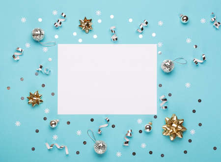 Christmas composition. Gold and silver decorations, mirror disco balls, gifts on pastel blue paper...