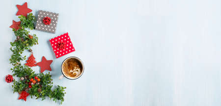 Rustic blue wooden background with cup of hot coffee, Christmas gifts and fir branches. Seasonal...