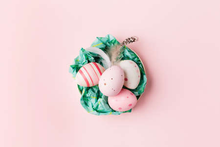 Easter eggs on pink pastel background with space for text. Flat lay image composition, top view....