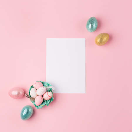 Gold, silver shiny Easter eggs on pink pastel background with space for text. Flat lay image composition, top view. Easter decoration, foil minimalist egg design, modern design template.の写真素材