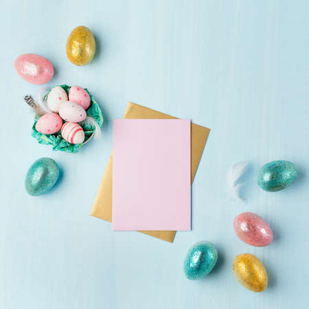 Gold, silver shiny Easter eggs on blue pastel background with space for text. Flat lay image...