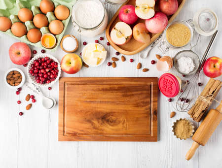 Autumn winter baking concept. Cooking baking background with ingredients, apples and utensils. Baking traditional autumn winter pie, rustic white wooden background, copy space.の写真素材