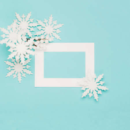 Christmas or winter composition. Frame made of snowflakes and festive decorations on pastel blue background. Christmas, winter, new year concept. Flat lay, top view, copy spaceの写真素材