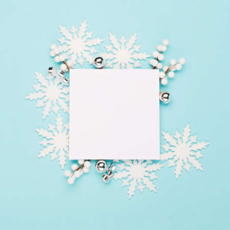 Christmas or winter composition. Frame made of snowflakes empty white paper on pastel blue background. Christmas, winter, new year concept. Flat lay, top view, copy spaceの写真素材
