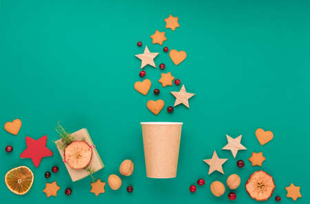Zero waste Christmas, New Year, winter drink concept. Trendy eco friendly craft cup of coffee to go and gingerbread cookies on green background. Copy space, flat lay, top viewの写真素材