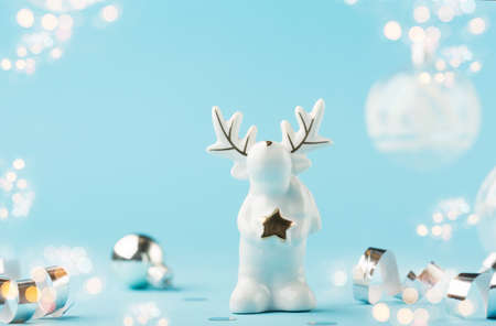Christmas card with small glass white reindeer, silver decorations, mirror disco balls on light blue...