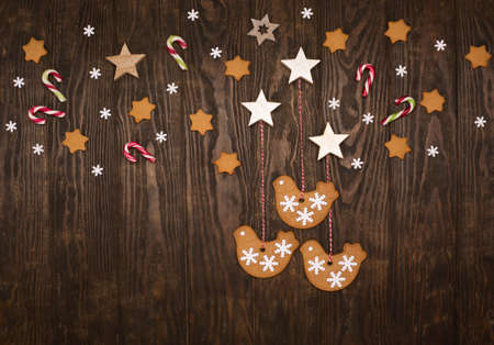 Christmas holiday background with homemade gingerbread cookies, candy canes, snowflakes on dark...