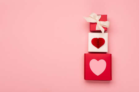 Paper hearts and festive gift boxes on pastel pink background. Valentines day concept. Flat lay, top...