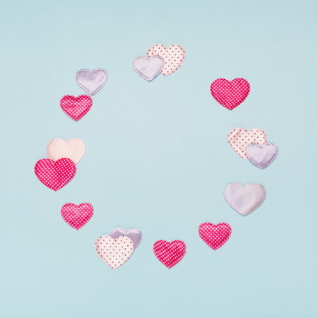 Pink, violet textile hearts with polka dots on blue background. Valentines day concept. Flat lay,...
