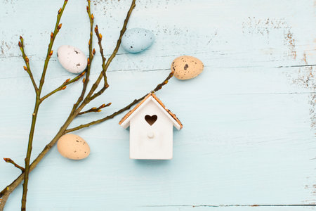 Easter craft eggs and branches on blue pastel background with space for text. Flat lay image...