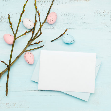 Easter craft eggs and branches on blue pastel background with space for text. Flat lay image composition, top view. Easter decoration, craft quail minimalist egg design. Spring holiday festive card.の写真素材