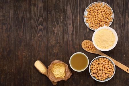 Cooked Chickpeas, aquafaba, chickpea flour on dark wooden background. Top view, copy space. Healthy, nutritious, and vegetarian food concept.の写真素材