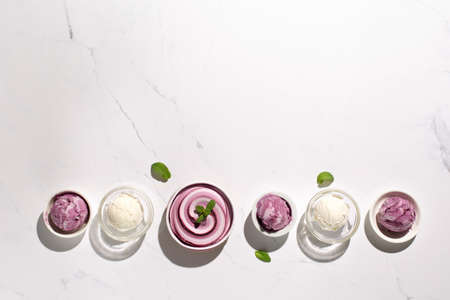 Homemade yogurt vanilla blueberry ice cream and fresh mint on natural stone marble background....