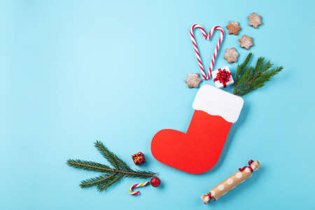 St. Nicholas Day - Red boot with sweets, spicy ginger cookies and gifts for December 6th on blue...