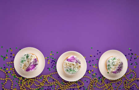 Mardi Gras King Cake sufganiyot donuts, masquerade festival carnival gold beads and golden, green,...