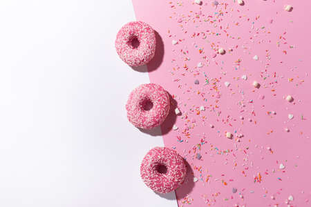 Happy national donut day. Donuts with pink icing and sugar sprinkles on pink and white background....