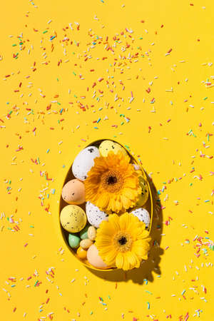 Festive holiday Easter composition. Yellow, pink and white sugar sprinkles, flowers, sweet Easter...