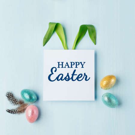 Bunny rabbit ears made of natural green leaves, Happy Easter text, Gold, silver shiny holiday eggs...