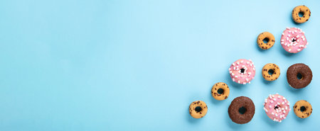Donuts donuts with chocolate, marshmallow and sugar sprinkles on blue background, copy space. Colorful carnival or birthday party card. Happy National donut day Concept.の写真素材