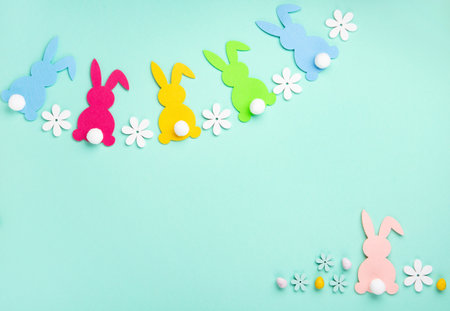 Colorful Easter Bunnies, Sweet Colorful Easter Eggs, daisy flowers on pastel blue mint background. Happy Easter greeting card concept, copy space.の写真素材