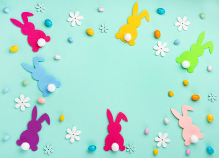 Colorful Easter Bunnies, Sweet Colorful Easter Eggs, daisy flowers on pastel blue mint background. Happy Easter greeting card concept, copy space.の写真素材