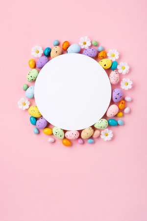 Sweet Colorful Easter Eggs and spring white daisy flowers on pastel pink background. Happy Easter greeting card concept. Flat lay, top view, copy space.の写真素材