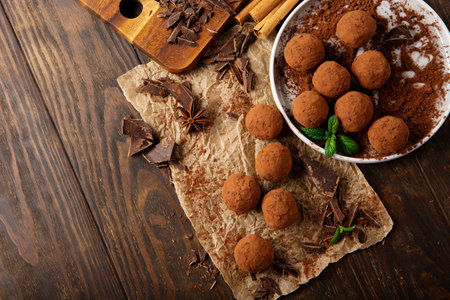 Homemade vegan chocolate truffles, round chocolate candies, with cocoa powder. Dark Chocolate and Coconut Butter on rustic wooden background. Handmade, Gluten free, Healthy dessert concept.の写真素材