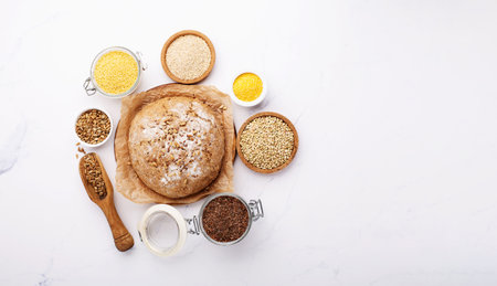 ancient grain food. Bread Gluten free, Healthy eating, dieting, balanced food concept. Cereals gluten-free, millet, quinoa, polenta, buckwheat, flax seeds, sunflower seeds on white background.の写真素材