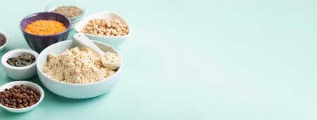 Plant based protein food (legumes, lentils, beans, seeds) and Healthy dry Pea Protein Powder, food supplement, Fitness nutrition on blue green background. Vegan, vegetarian food concept.の写真素材