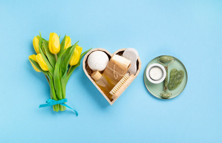 Natural eco friendly beauty skin care products, spa accessories for women and spring tulip flowers on blue background. Zero waste self care heart shape gift box for Mothers day, womans day, birthday.の写真素材