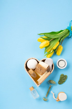 Natural eco friendly beauty skin care products, spa accessories for women and spring tulip flowers on blue background. Zero waste self care heart shape gift box for Mothers day, womans day, birthday.の写真素材