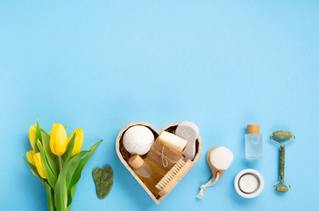 Natural eco friendly beauty skin care products, spa accessories for women and spring tulip flowers on blue background. Zero waste self care heart shape gift box for Mothers day, womans day, birthday.の写真素材