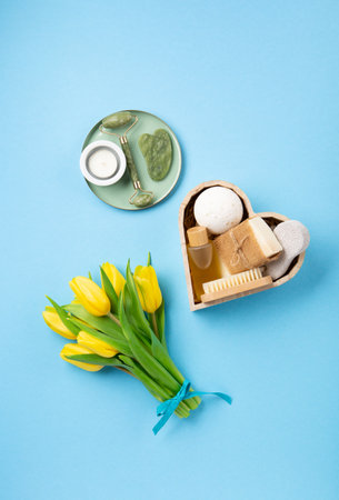 Natural eco friendly beauty skin care products, spa accessories for women and spring tulip flowers on blue background. Zero waste self care heart shape gift box for Mothers day, womans day, birthday.の写真素材