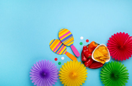 Mexican background fiesta with Traditional Mexican nachos chips, red chilli pepper, cactus and maracas on blue background. Cinco de Mayo (Fifth of May) celebration concept. Top view, copy space.の写真素材