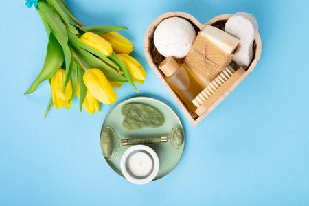 Natural eco friendly beauty skin care products, spa accessories for women and spring tulip flowers on blue background. Zero waste self care heart shape gift box for Mothers day, womans day, birthday.の写真素材